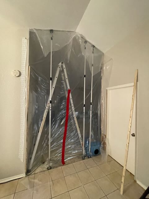 Tension-post plastic containment barrier isolating the contaminated work area