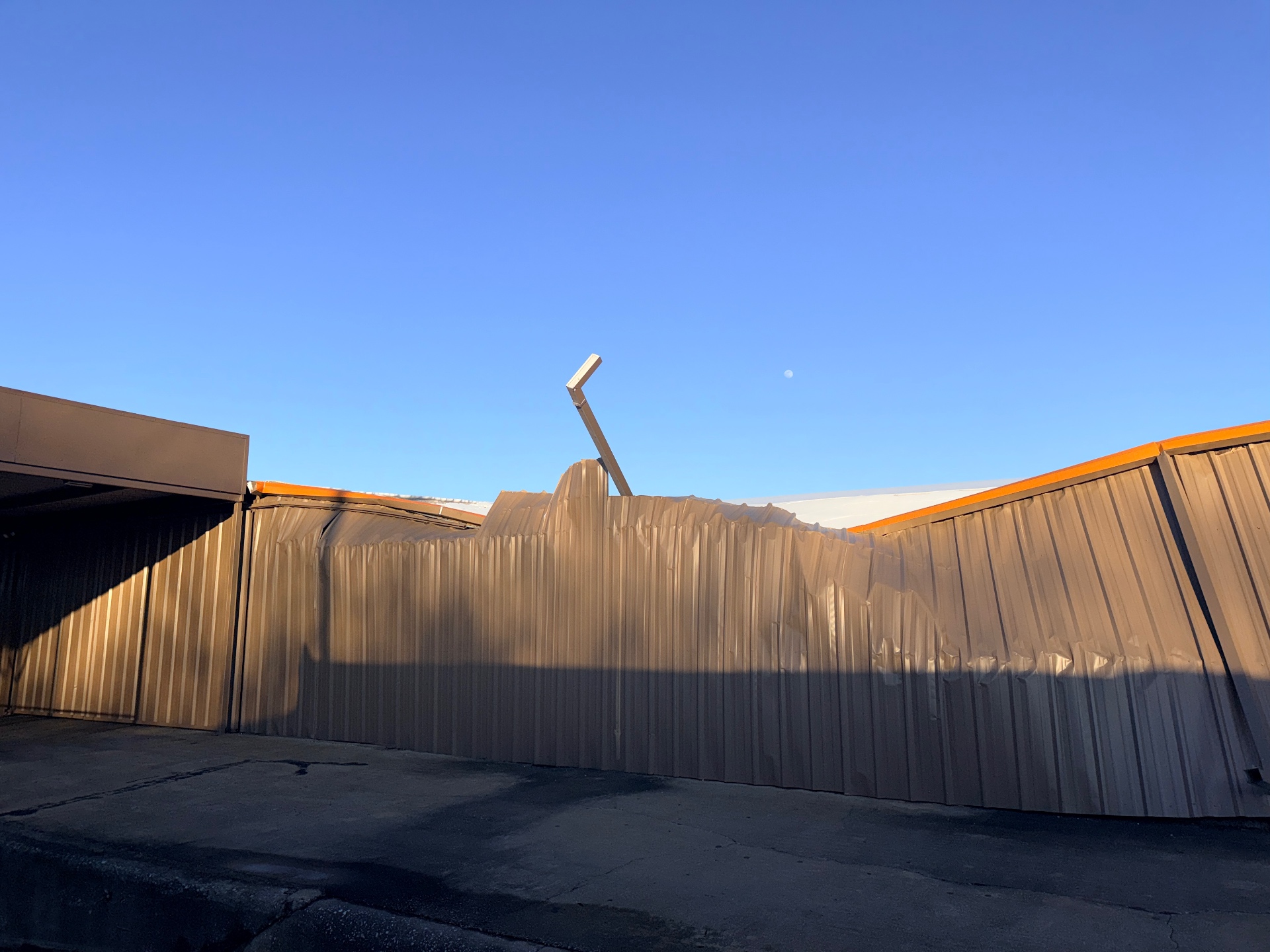 Before – Buckled metal wall panels showing structural displacement – Gainesville TX