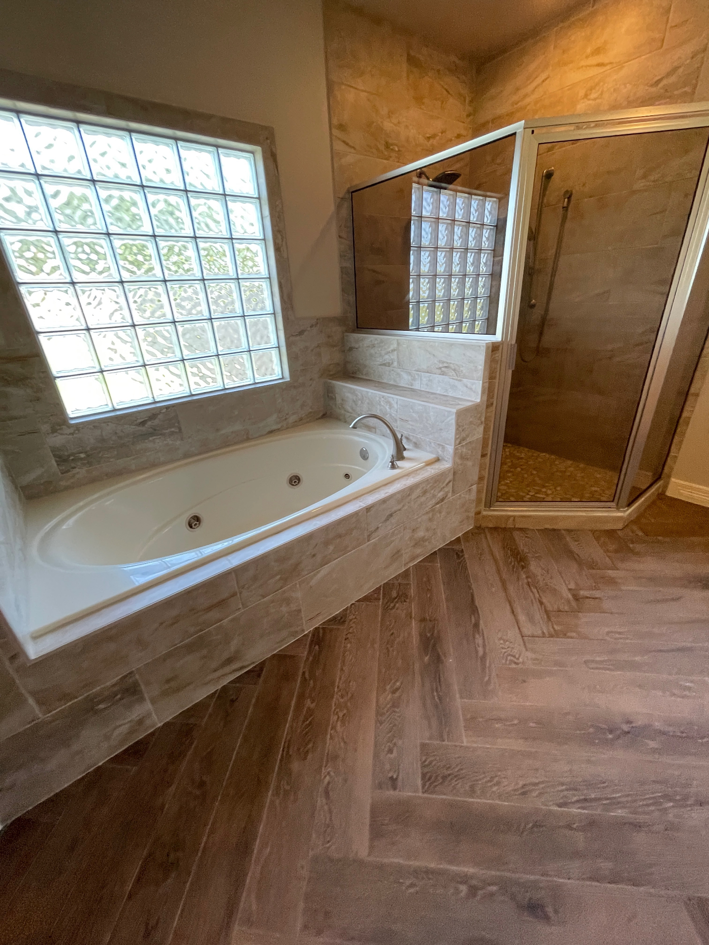 After – Fully restored bathroom with custom tile, jetted tub, and glass shower – New Braunfels